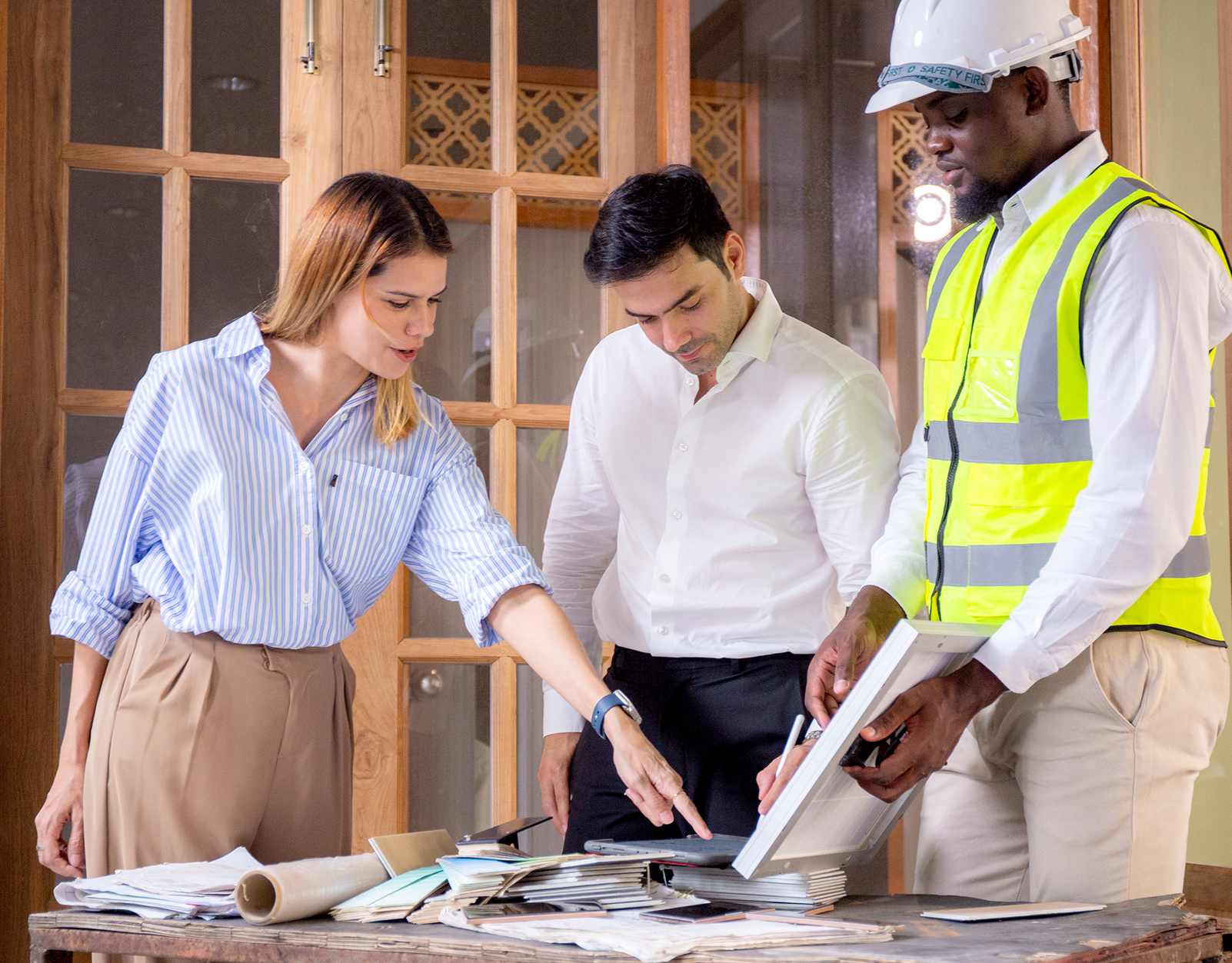 Construction team reviewing blueprints indoors