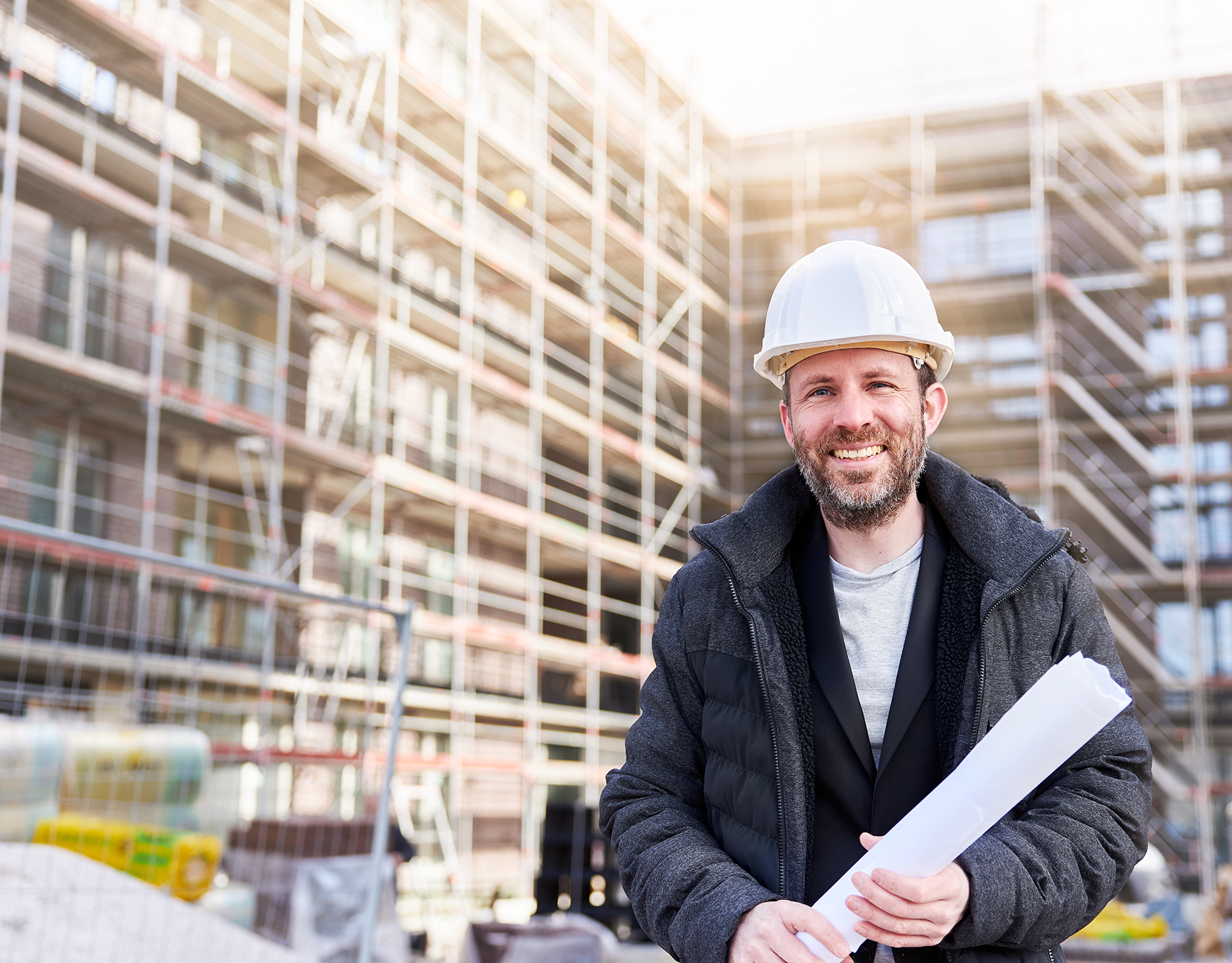 Architect with blueprints at construction site